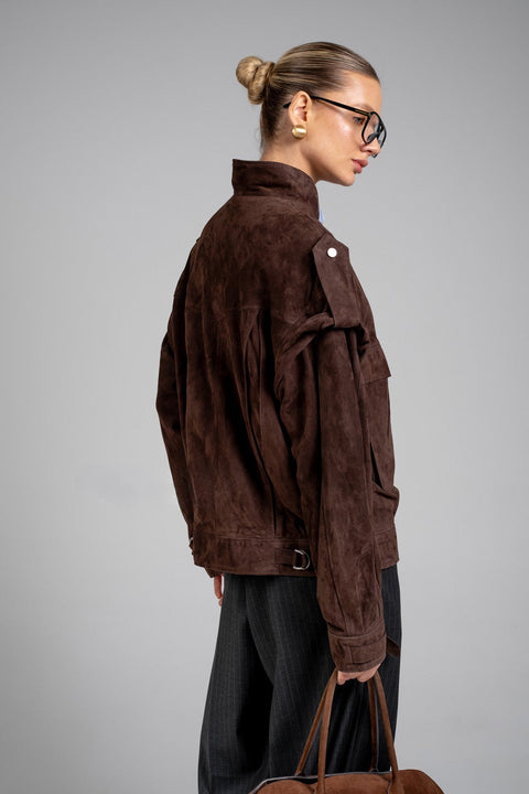 The model showcases a rich dark brown suede jacket with a flattering fit, perfect for casual and elevated outfits.