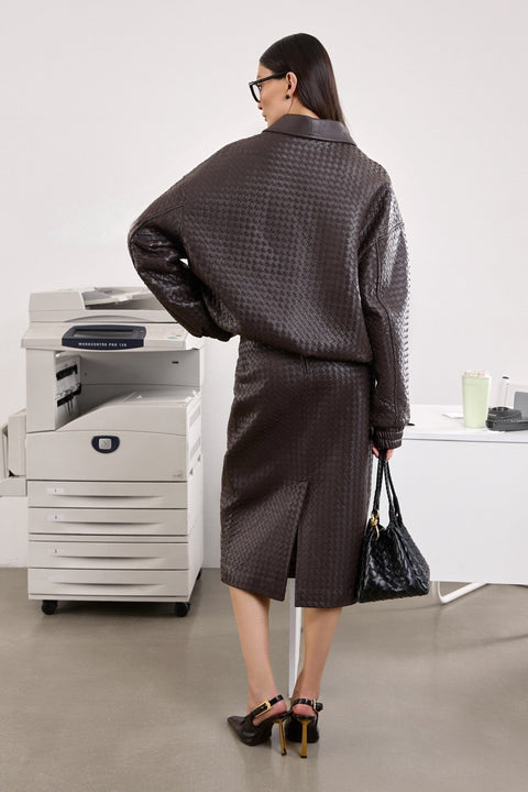 A woman models a deep-hued brown bomber jacket featuring a comfortable relaxed fit and practical side pockets, effortlessly combining style and function.