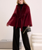 Elegant woman in burgundy cashmere cape with fox fur trim, showcasing rich color and luxurious winter style.