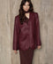 A woman wearing a super trendy burgundy woven blazer with a sharp silhouette and structured shoulders, exuding elegant and chic sophistication.