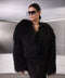 A woman wears the luxurious black Mongolian Coat, handcrafted from thick, soft 100% genuine Mongolian fur, featuring a sleek one-piece design and practical side pockets.