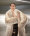 Draped in a gold fox fur coat, the woman radiates luxury and refinement, showcasing the plush texture and exquisite craftsmanship of this opulent winter statement piece.