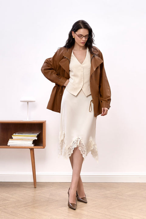 Draped in the Simona Genuine Leather Jacket, a woman presents a sophisticated blend of sporty edge and chic comfort with a high-neck design.